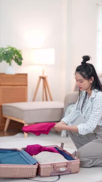 아시아 여자는 조심스럽게 그녀의 가방에 그녀의 소지품을 장시간 주말에 모험적인 — 비디오