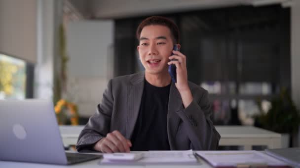 Der Junge Asiatische Geschäftsmann Plaudert Schreibtisch Über Die Arbeit Telefon — Stockvideo