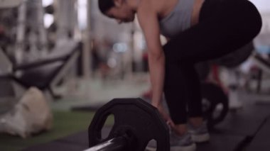 Asyalı bir kadın, halter kaldırarak sağlığa, bacak ve sırt kaslarına tutkuyla bağlıdır. Zindelik yolculuğuna kendini adamış, gücünü arttırmış ve güçlü bir fiziğe ulaşmıştır. Yüksek kalite 4k görüntü