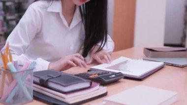Genç Asyalı bayan üniversite öğrencileri çeşitli istatistiksel değerleri hesaplamak için matematik ödevleri üzerinde özenle çalışıyorlar. Yüksek kalite 4k görüntü
