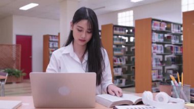 Genç Asyalı kız üniversite öğrencileri müzik dinleyerek çalışmaktan keyif alıyorlar. Yüksek kalite 4k görüntü