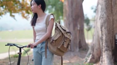 Asyalı kadın bisikletini gezdirirken bisikletçiliğe ara veriyor. Yüksek kalite 4k görüntü