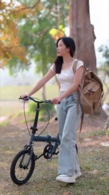 Asyalı kadın bisikletini gezdirirken bisikletçiliğe ara veriyor. Yüksek kalite 4k görüntü