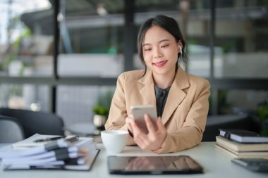 Bluetooth kulaklık takan iş kadınları ve yeni iş dünyasının mali ve yatırım verileri ile ilgili video görüşmeleri için akıllı telefon kullanıyorlar..