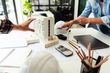 Ofisteki inşaat projesinin kondominyum modeli hakkında iki mühendis tartışması ve beyin fırtınası.