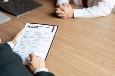 İnsan Kaynakları müdürü kadın özgeçmiş okuyor ve iş görüşmeleri sırasında erkek adayla sorular soruyor..