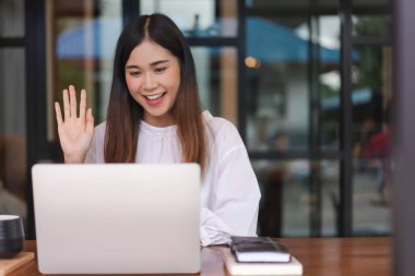 İş kadınları ofis dışında çalışırken iş arkadaşlarıyla görüntülü görüşme ve selamlaşır.