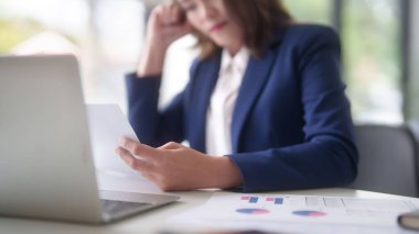 Asyalı iş kadınları pazarlama iş raporlarını okurken ve finans tablosunu kontrol ederken yeni iş stratejisi hakkında düşünürken aynı zamanda ofis dışında yeni bir girişimin yatırım ve pazar stoklarını analiz ediyorlar..