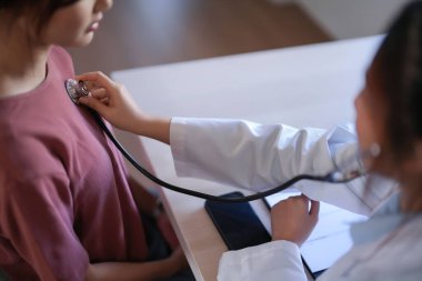 Asyalı psikolog kadınlar hastaları kontrol etmek için steteskop kullanırken ve ilaç ve zihinsel sağlık terapisi hakkında danışmanlık yaparken, kadın hastalar psikolojik sağlık sorunu ve strese maruz kalıyor..