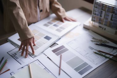 Kadın mimar, bina projesinin iç tasarımı için renk örneği seçiyor..