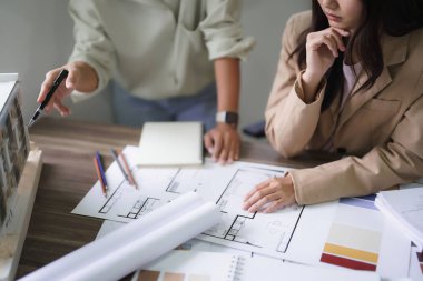 İki kadın mimar plandaki model ve iç tasarım hakkında tartışıyor ve beyin fırtınası yapıyor..