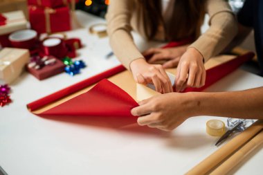 Genç bir adam ve kadın mutlu bir şekilde masayı dolduruyor, birlikte eğlenceli bir anı paylaşıyorlar. Etrafları Noel süsleriyle çevrili ve bir Noel ağacı festival atmosferine katılıyor..