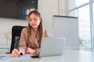  İş kadınlarının elleri evrak ve bilgisayarla çalışırken ofiste notlar yazarlar.