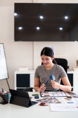 Yaratıcı ofiste online toplantı sırasında tablet aracılığıyla iç tasarım fikirleri sunan genç mimar