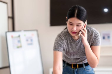 Modern çalışma alanındaki malzeme paletini incelerken iç mimar projeyi telefonda tartışıyor