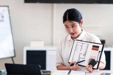 Yaratıcı ofiste online toplantı sırasında dizüstü bilgisayarla iç tasarım fikirleri sunan genç mimar