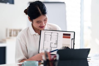 Yaratıcı ofiste online toplantı sırasında dizüstü bilgisayarla iç tasarım fikirleri sunan genç mimar