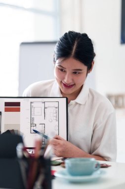 Yaratıcı ofiste online toplantı sırasında dizüstü bilgisayarla iç tasarım fikirleri sunan genç mimar