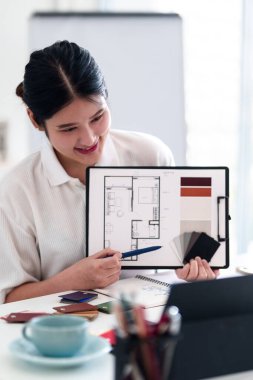 Yaratıcı ofiste online toplantı sırasında dizüstü bilgisayarla iç tasarım fikirleri sunan genç mimar