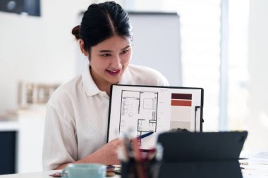 Yaratıcı ofiste online toplantı sırasında dizüstü bilgisayarla iç tasarım fikirleri sunan genç mimar