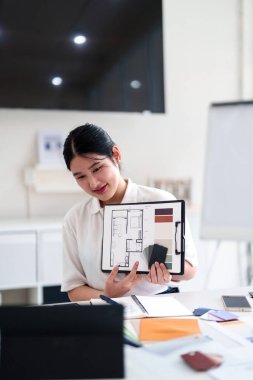 Yaratıcı ofiste online toplantı sırasında dizüstü bilgisayarla iç tasarım fikirleri sunan genç mimar