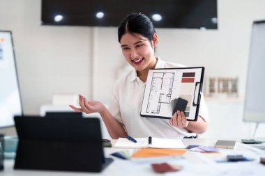 Yaratıcı ofiste online toplantı sırasında dizüstü bilgisayarla iç tasarım fikirleri sunan genç mimar