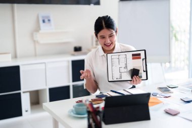Yaratıcı ofiste online toplantı sırasında dizüstü bilgisayarla iç tasarım fikirleri sunan genç mimar