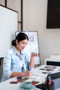Tasarım stüdyosunda renk ve malzeme seçimi üzerinde çalışırken iç mimar iş görüşmesi yapıyor
