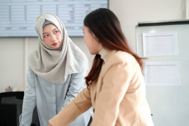 İki genç Asyalı iş kadını modern bir ofiste iş tartışıyorlar. Biri tesettürlü Müslüman bir kadın. Bir toplantı sırasında iş yerinde beyin fırtınası yapıyorlar..