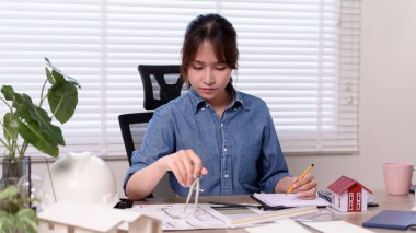 Genç bir Asyalı mimar inşaat planlama ve bina planı için hassas araçlara sahip bir bina planı tasarlıyor. Ayrıntılı tasarımlar yapmaya odaklanmış..