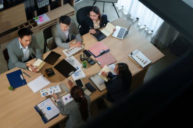 Modern bir ofisteki toplantı sırasında Asyalı bir iş adamının üst düzey görüşü. Yetişkin erkek ve kadınlar finansal verileri analiz ediyor, büyümeyi tartışıyorlar.
