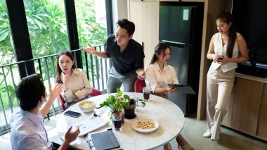 Asyalı profesyoneller iş görüşlerini tartışmak, projelerde işbirliği yapmak ve atıştırmalıkları paylaşmak için bir ofiste toplandılar. Modern ortam, şirket büyümesi için takım çalışmasını ve yeniliği teşvik etmektedir..