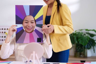 Asyalı genç bir kadın kişisel renk analizi seansı yapıyor. Makyaj ve kıyafet seçimlerinde ona rehberlik edecek en uygun renkleri keşfediyor..