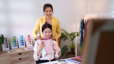 Asian women receive personal color analysis to find their flattering colors. Stylist helps choose perfect wardrobe based on seasonal color palettes and fashion trends.