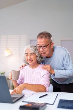 Bu yürek ısıtan sahne, yaşlı bir Asyalı çiftin bilgisayarla modern teknolojinin rahatlığından keyif aldığını gösteriyor..