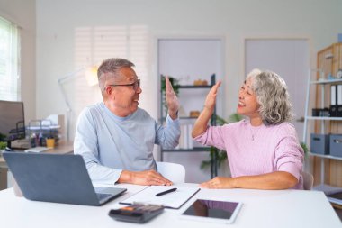 Neşeli, yaşlı bir Asyalı çift ev ofisinde bir beşlik çakarak başarıyı kutluyor. Emekliliklerinin tadını çıkarıyorlar ve mutlulukla hedeflerini paylaşıyorlar..