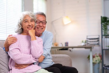 Bu iç açıcı görüntü, yaşlı ve sevgi dolu Asyalı bir çiftin evde emekliliğin tadını çıkarmasını yansıtıyor. Aşka ve arkadaşlığa sarılıyorlar, gösteriş yapıyorlar..