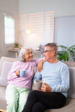Yaşlı bir Asyalı çift, rahat bir atmosferde kahvelerini yudumlarken huzur dolu bir anı paylaşıyor. Onlar emeklilikteki aşk ve mutluluğun resmidir.