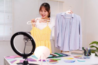 Genç Asyalı kadınlar kişisel renk analizlerine çevrimiçi antrenörlük yapıyor ve moda tasarımı için elbise ve gömlek tarzı uyum sağlıyorlar. Mükemmel görünüm için doğru tonu seç