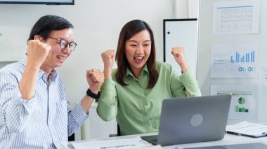 İki heyecanlı Asyalı profesyonel yaşlı bir adam ve yetişkin bir kadın ofis ortamında iş başarısını kutluyor. Sürdürülebilirlik hedefleri ve olumlu ESG etkisi konusunda mutlular. İşbirlikleri başarılı sonuçlara ve parlak...