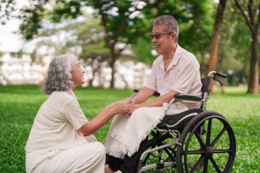 Asyalı yaşlı çift, mutlu anları paylaşıyor. Asyalı adam, tekerlekli sandalye, Asyalı kadın, emeklilik yaşam tarzını önemsiyor.
