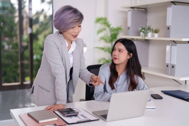 İki Asyalı iş kadını verimli bir ofis tartışmasına giriştiler. Tecrübeli bir akıl hocası, genç bir profesyonele iş yerinde görüşlerini paylaşma konusunda rehberlik eder..