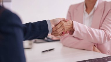 Profesyonel yetişkinler sıkı tokalaşıyor. Bu hareket, güven, başarılı anlaşma, işe alım veya yeni iş ortaklığını temsil eder..