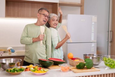 Neşeli Asya 'lı son sınıf öğrencileri sağlıklı ürün mutfağı hazırlayın. Taze sebzelerin tadını çıkarın. Birlikte sağlıklı yaşam tarzı ev yemekleri pişirin.