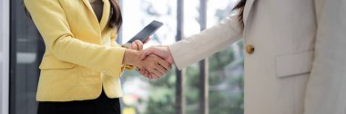 Two professional women initiate successful business agreement with firm handshake This signifies trust mutual respect and future collaboration