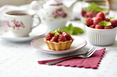 Masada çay ile servis edilen ahududulu mini tartlar.