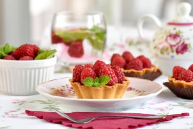 Masada çay ile servis edilen ahududulu mini tartlar.