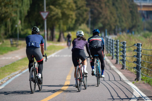 Велогонщики на велосипедной дорожке реки Ханган в Сеуле 16 октября 2022 года