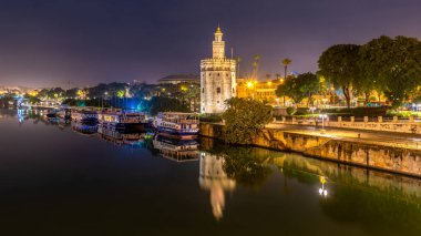 Altın Kule Torre del Oro 7 Aralık 2022 'de Sevilla, Endülüs, İspanya' da Guadalquivir nehri boyunca gece boyunca gözetleme kulesi