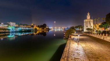 Altın Kule Torre del Oro 7 Aralık 2022 'de Sevilla, Endülüs, İspanya' da Guadalquivir nehri boyunca gece boyunca gözetleme kulesi
